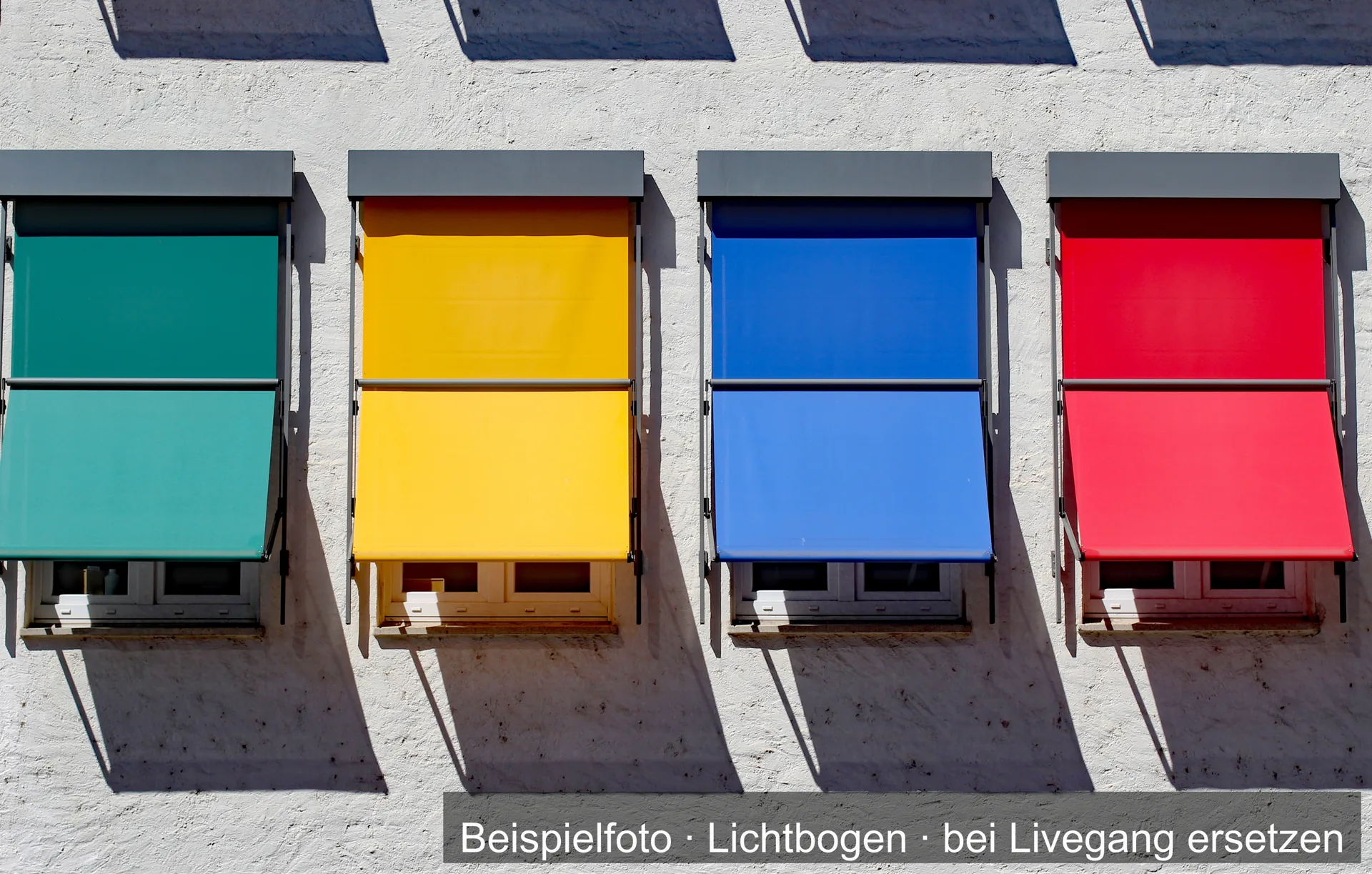 Vier Fallarmmarkisen in Grün, Gelb, Blau und Rot an einer hellen Fassade.