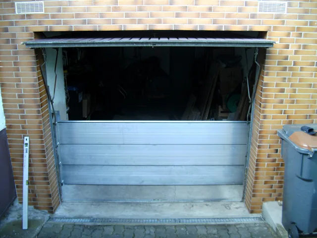 Dammbalken-Abschottung aus Aluminium in einer Toröffnung vor einer Klinkerwand.