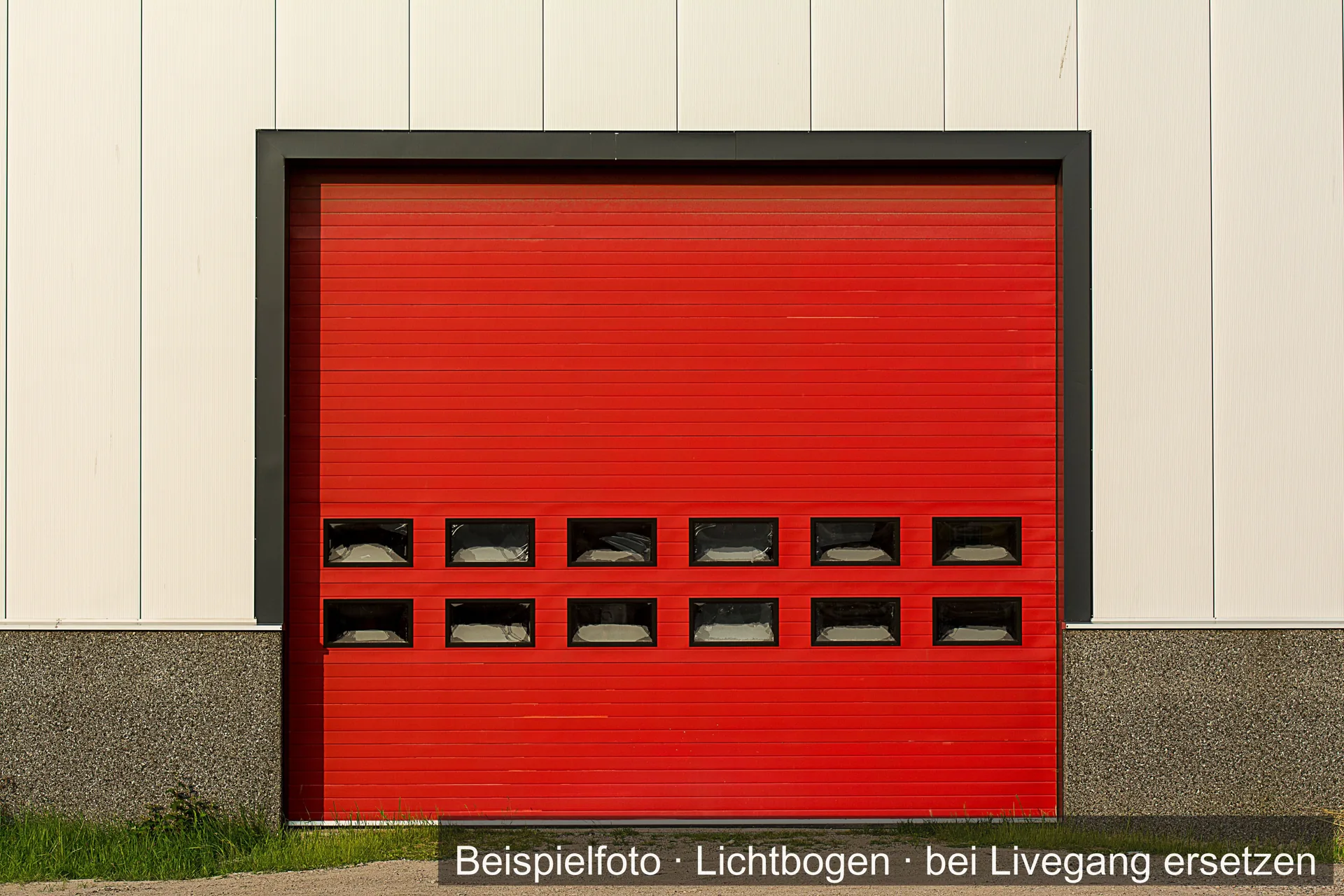 Rotes Rolltor in der hellen Wand einer Halle.